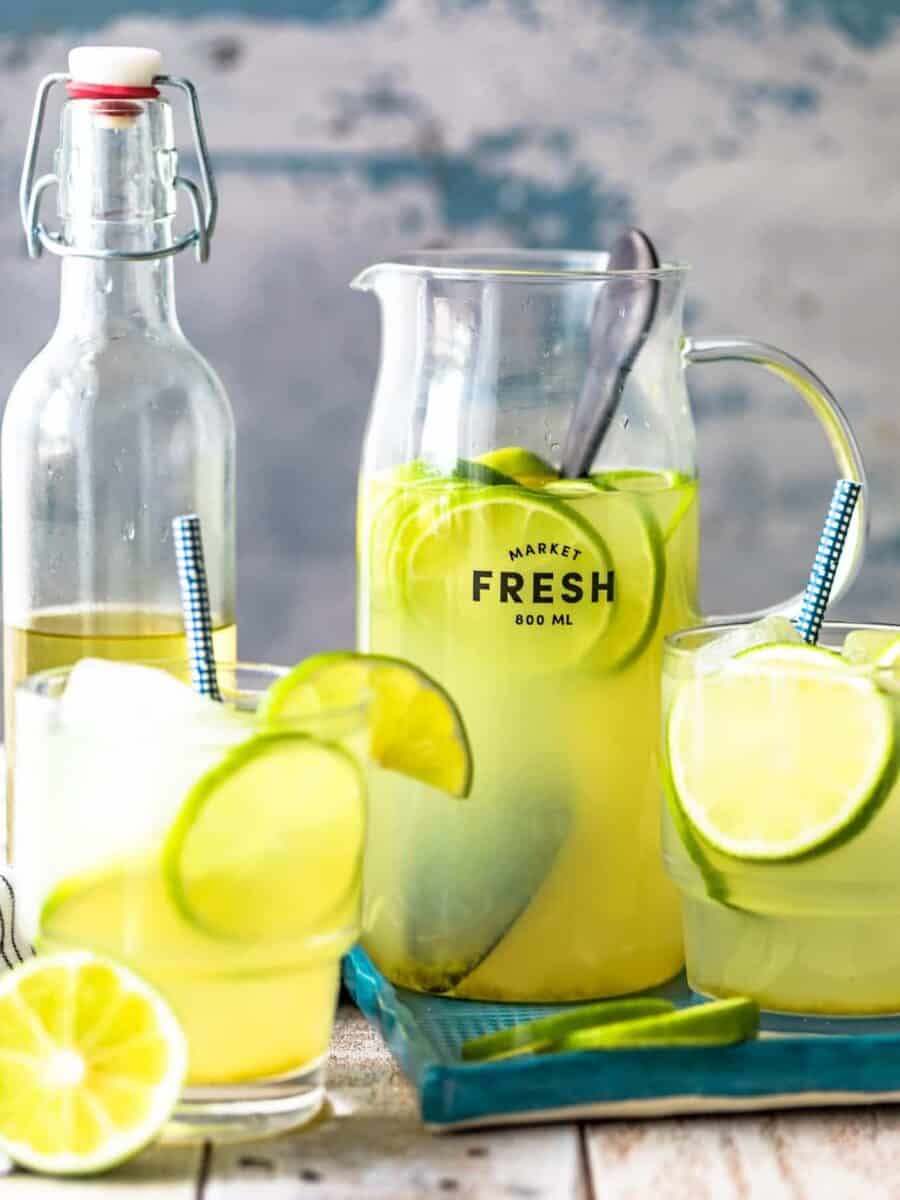 fresh lemonade and limeade in pitchers on a wooden table.