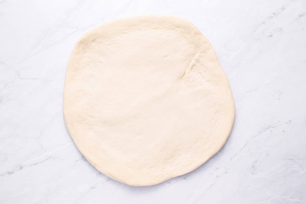 pizza dough spread in a circle.