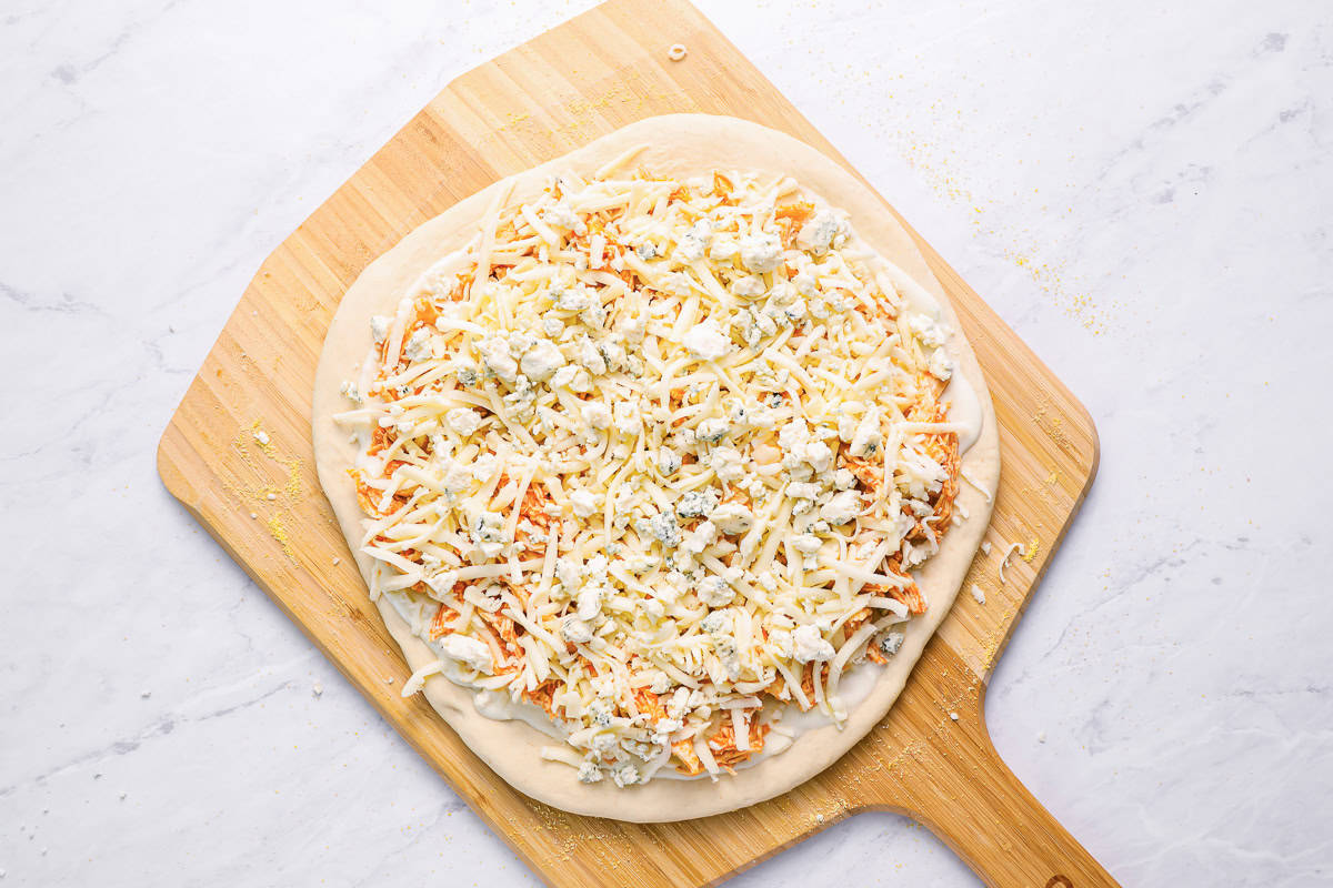 buffalo chicken pizza on a pizza peel.