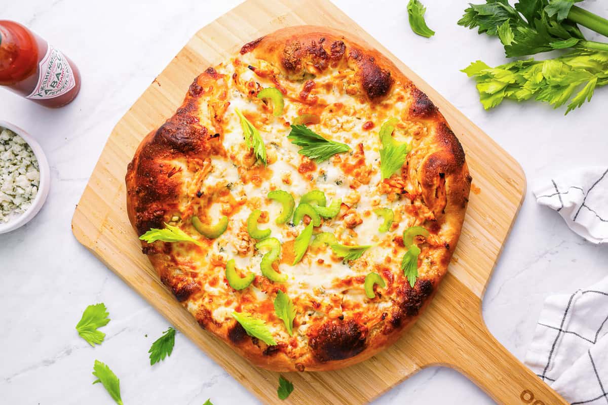 baked buffalo chicken pizza on a pizza peel.