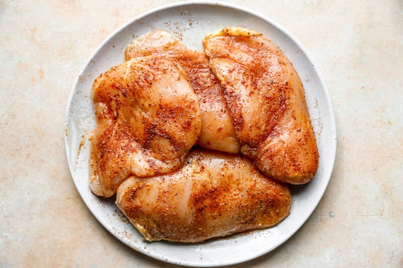 seasoned chicken breasts on a white plate.