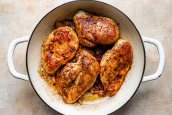 cooked seasoned chicken breasts in a pan.