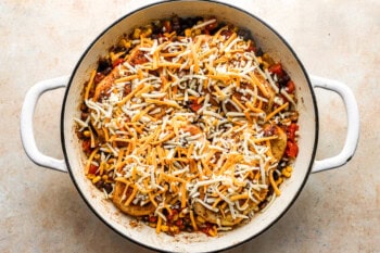 cowboy chicken topped with shredded cheese in a pan.