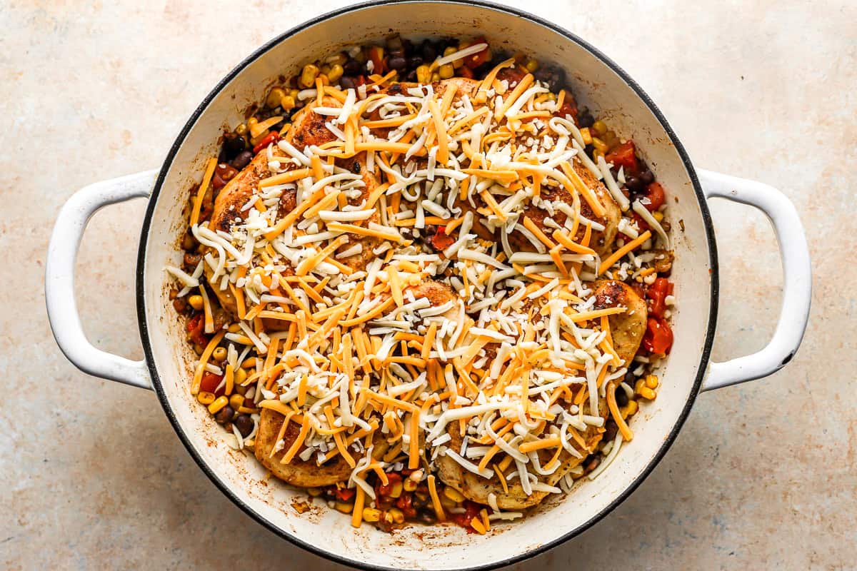 cowboy chicken topped with shredded cheese in a pan.