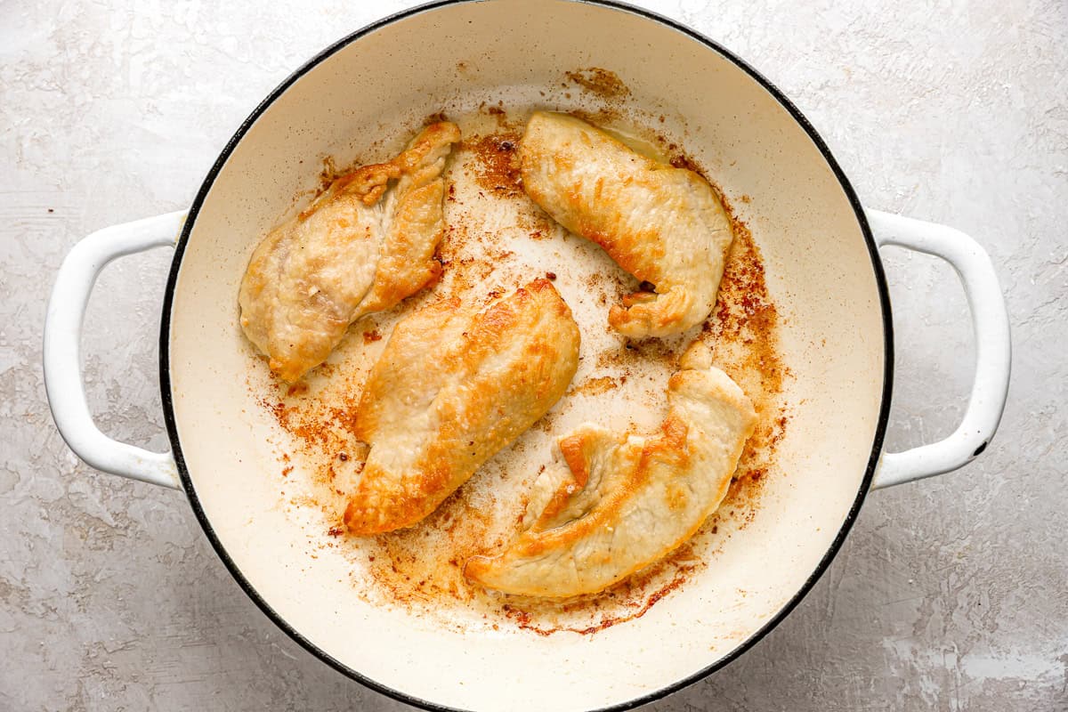 seared chicken in a Dutch oven.