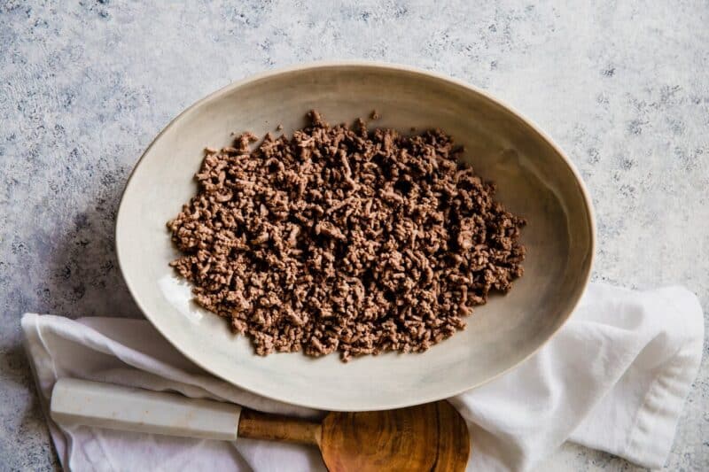 Cook ground beef with a wooden spoon.