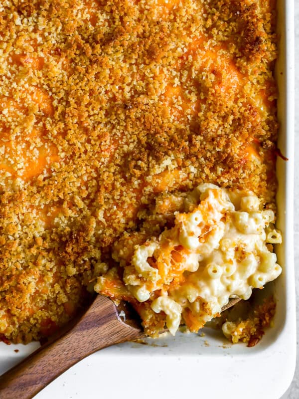 overhead view of a spoonful of baked mac and cheese resting in a casserole dish.