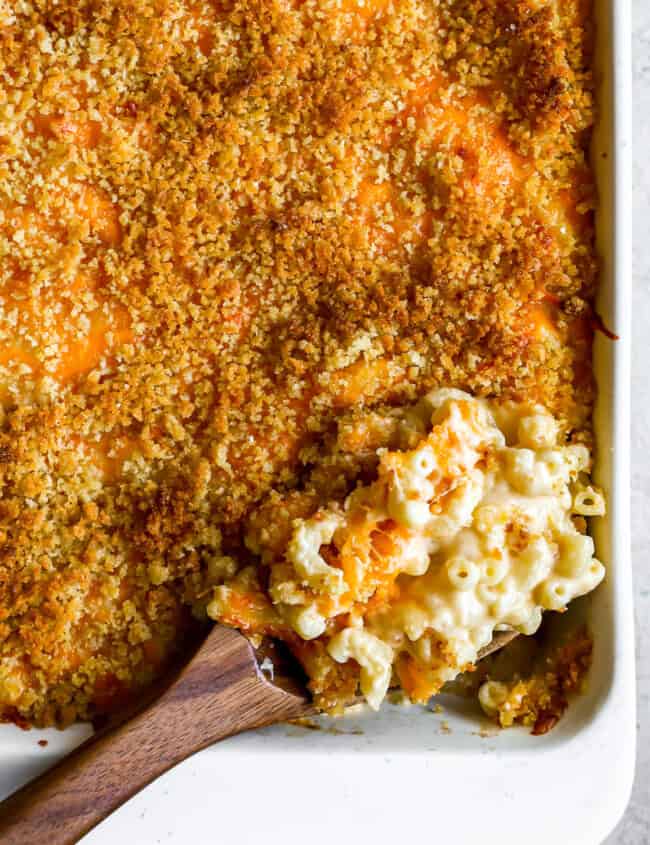 overhead view of a spoonful of baked mac and cheese resting in a casserole dish.