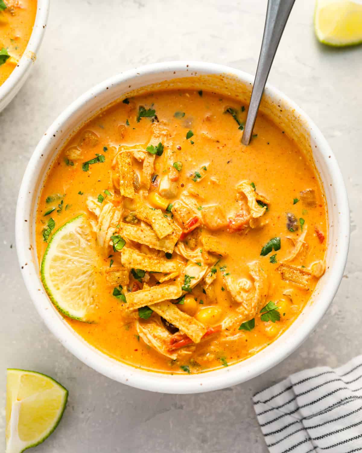 a bowl of chicken enchilada soup with a spoon.