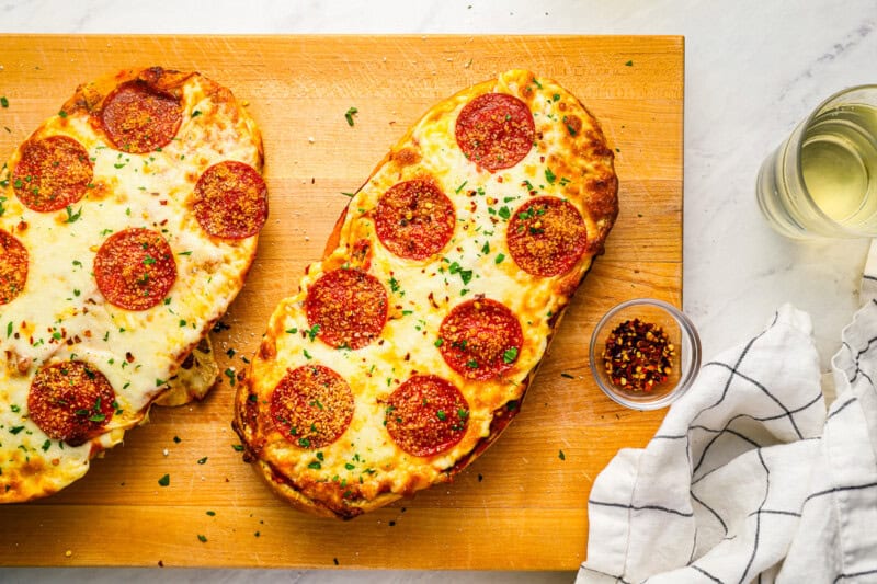 2 garlic bread pizzas topped with pepperonis.