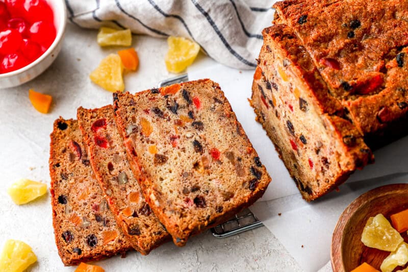 A loaf of fruitcake partially cut into slices.