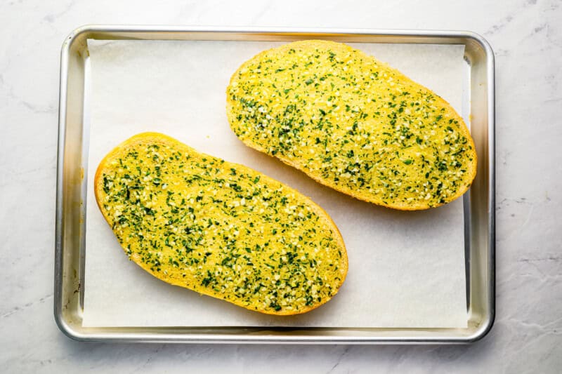 2 pieces of French bread topped with garlic butter.