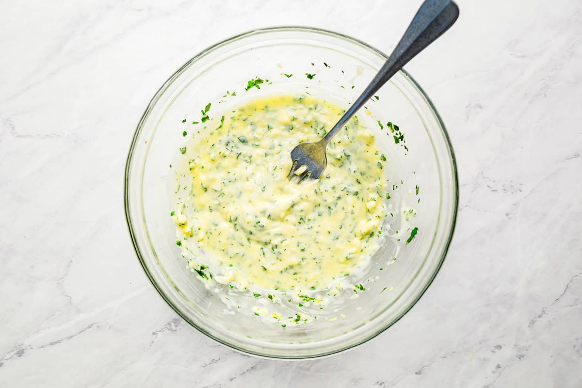 Garlic butter mixture in a glass mixing bowl.