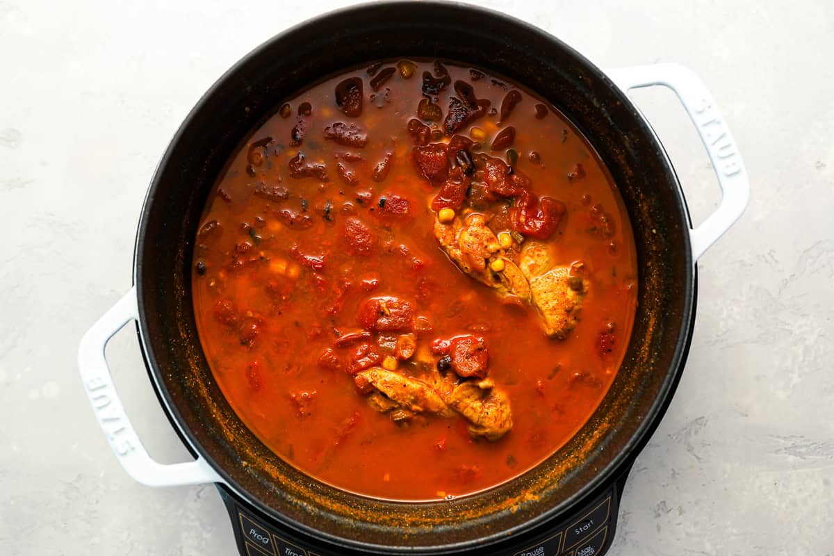 chunky tomato soup with chicken in a dutch oven.