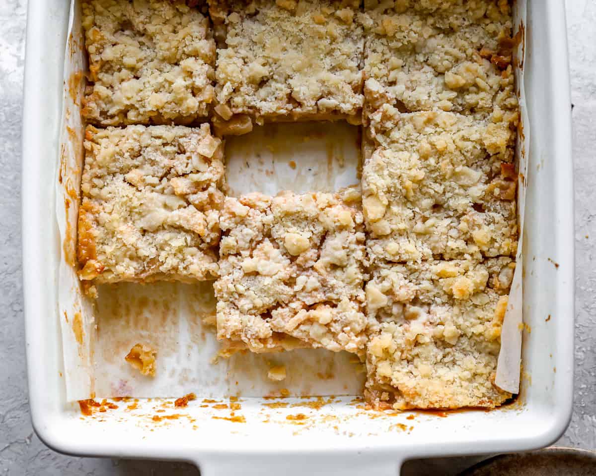 sliced apple pie bars in a square baking dish.