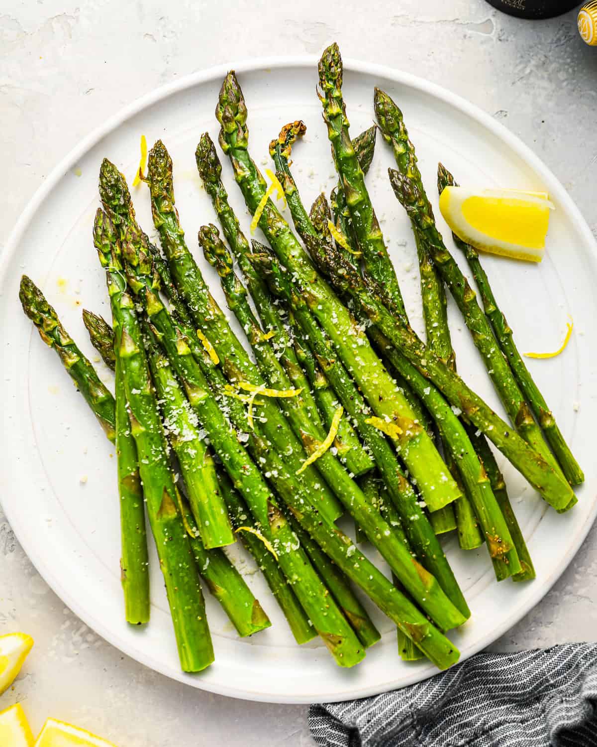 asparagus spears on a plate with lemon.