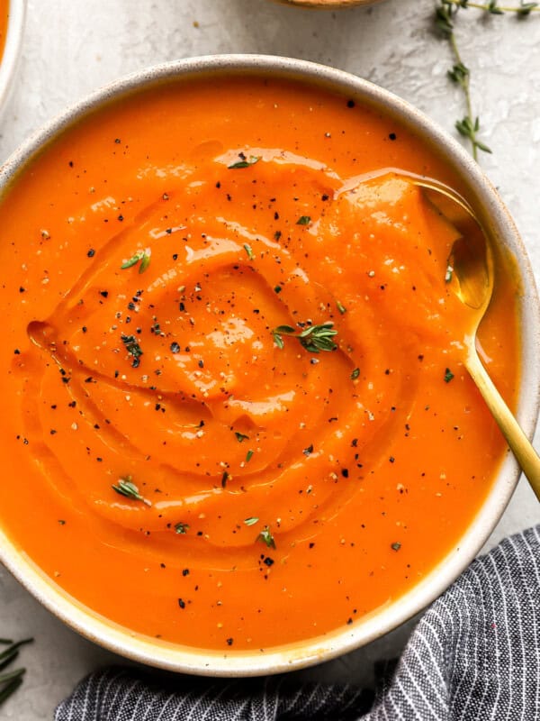 overhead view of a bowl of butternut squash soup with a spoon.