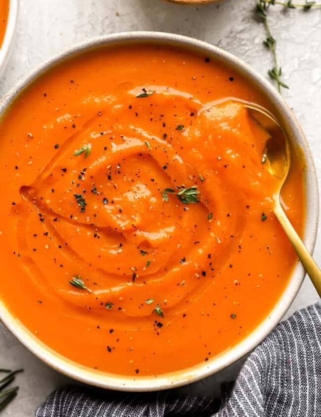 overhead view of a bowl of butternut squash soup with a spoon.