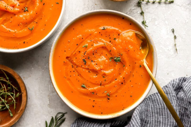 overhead view of a bowl of butternut squash soup with a spoon.