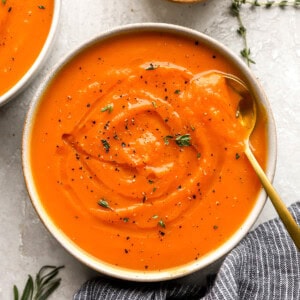 overhead view of a bowl of butternut squash soup with a spoon.