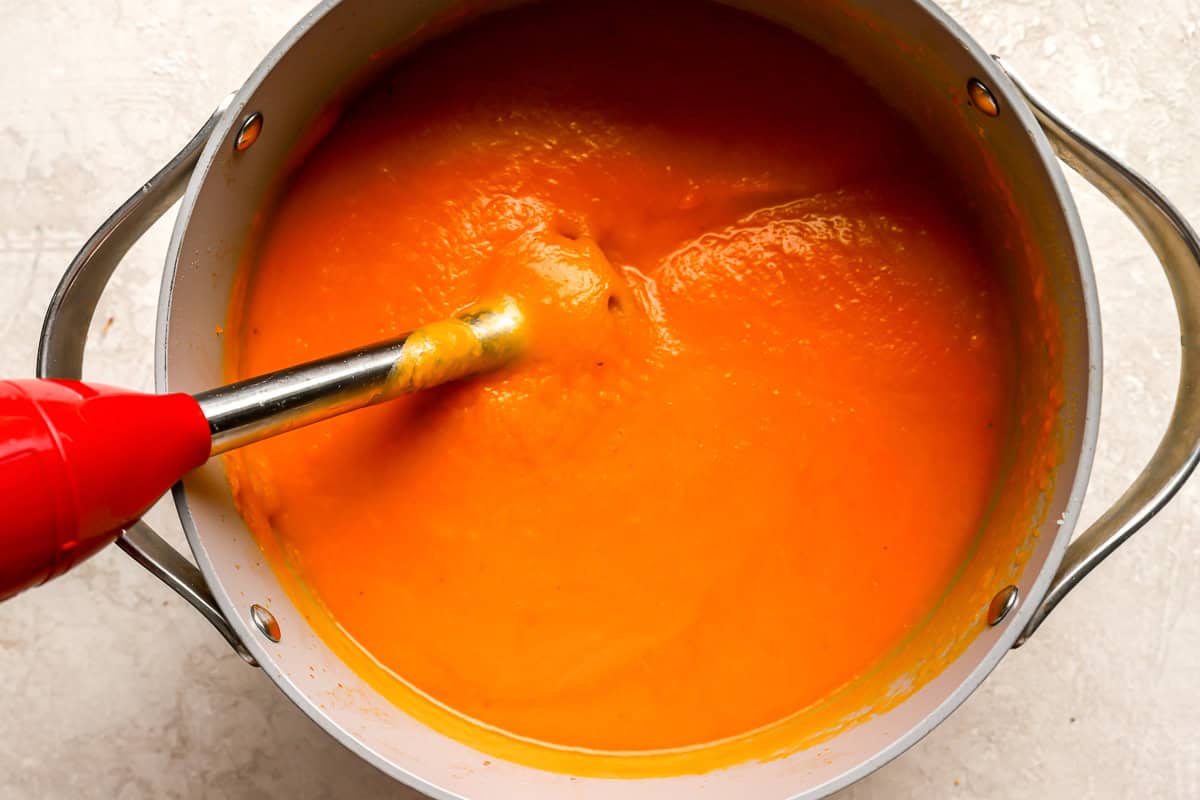 blending butternut squash soup in a large pot with an immersion blender.