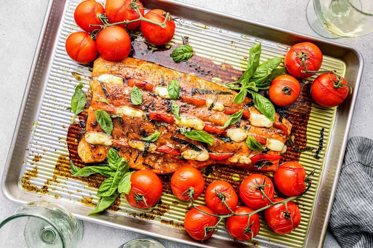 Caprese salmon on a baking tray.