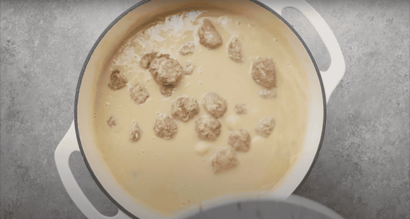 Creamy soup filled with meatballs in a Dutch oven.