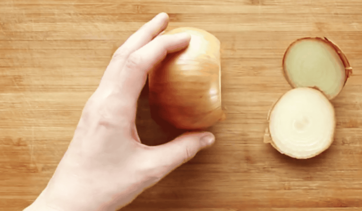 Cutting the ends off of an onion to peel.