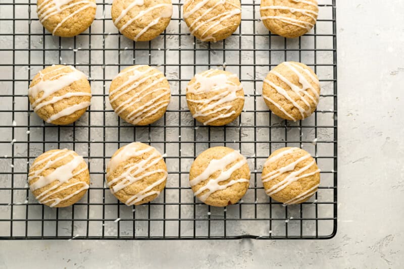 apple cider cookies on a wire rack drizzled with icing.