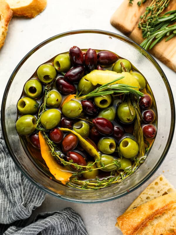 overhead view of marinated olives in a glass bowl.