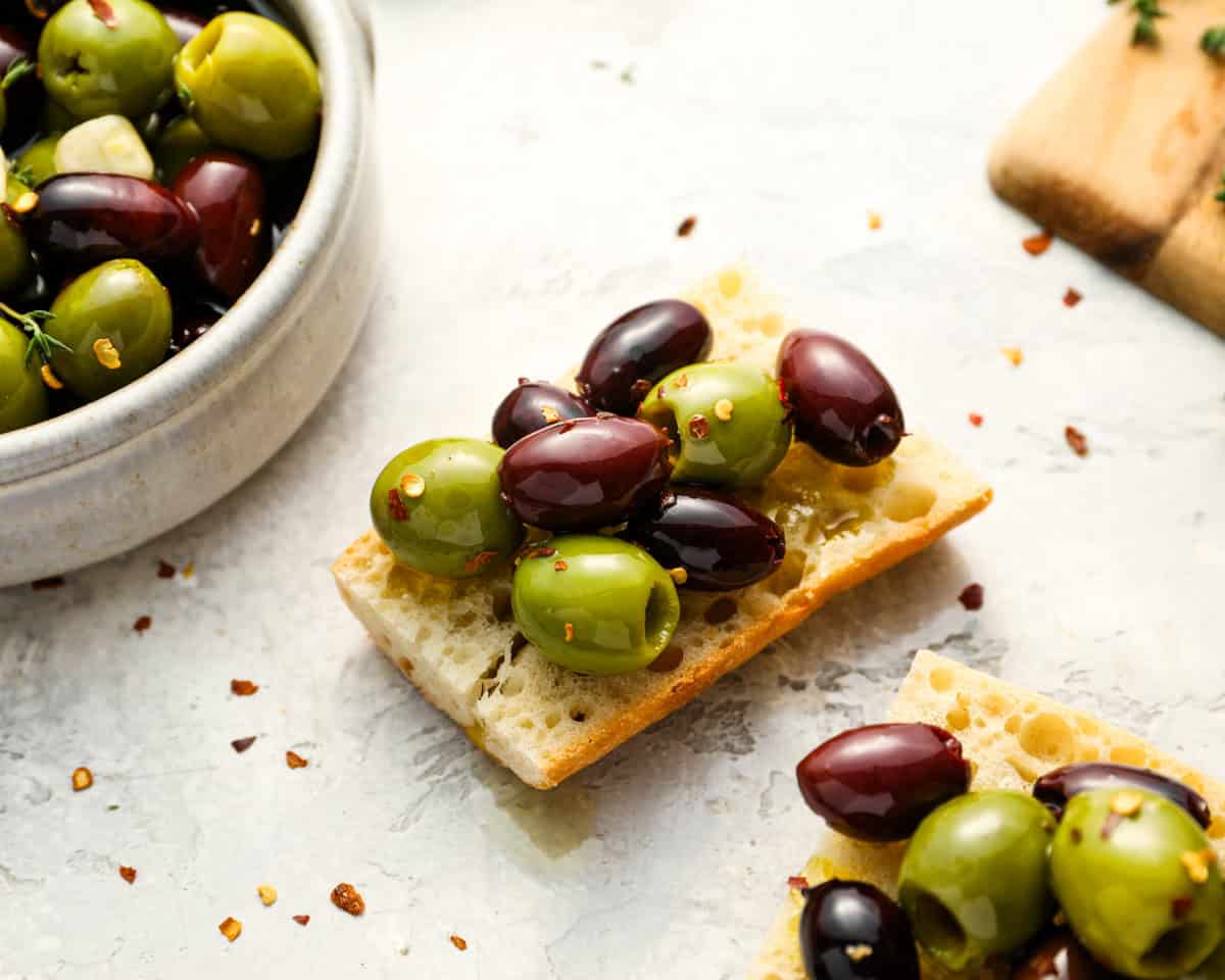 marinated olives on a cracker.