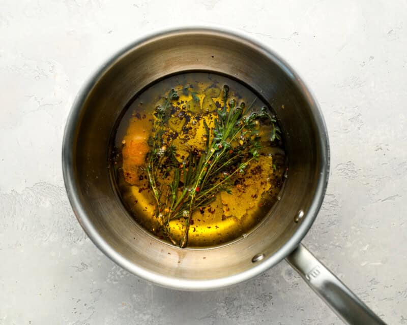 olive oil with herbs and spices in a pot.