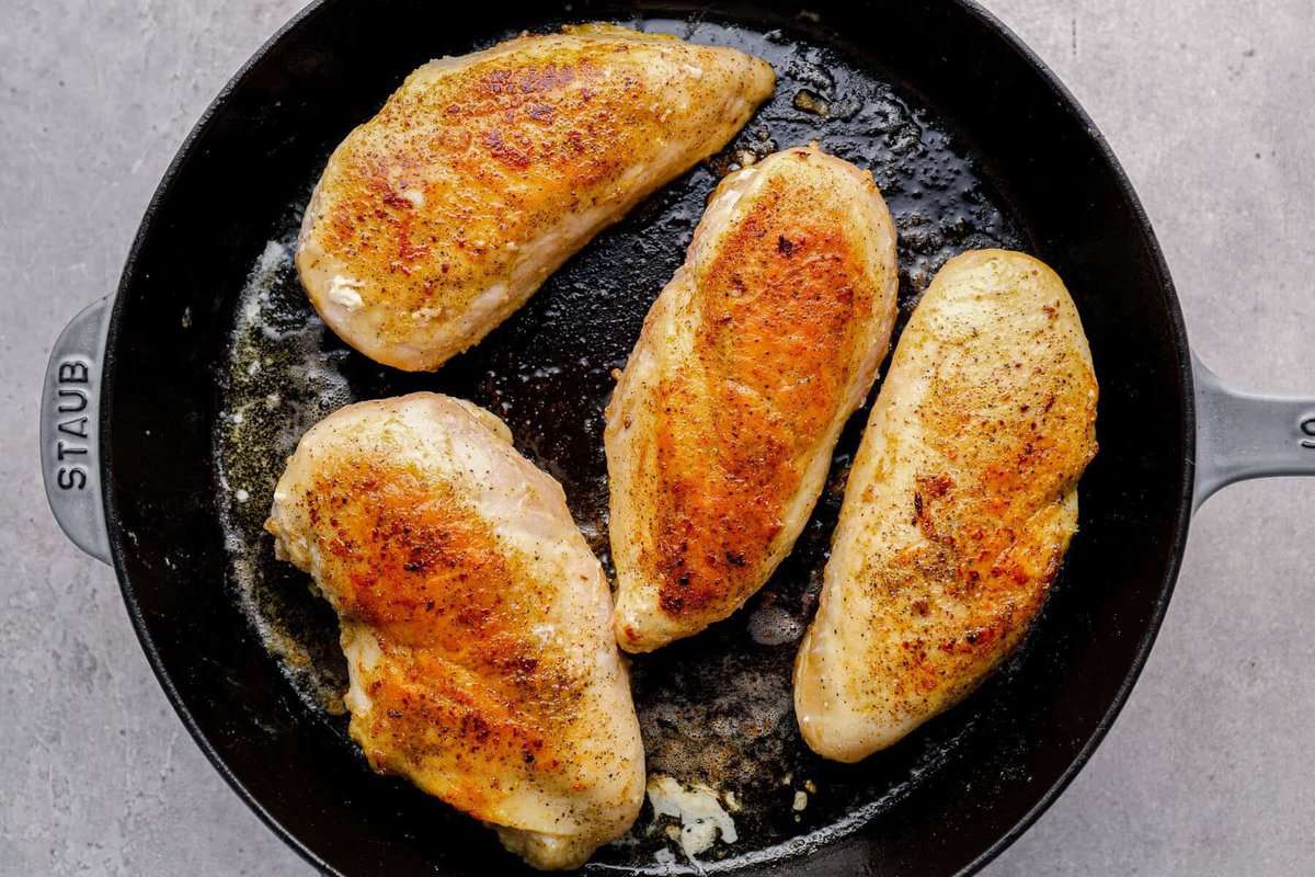 4 chicken breasts in a skillet after cooking