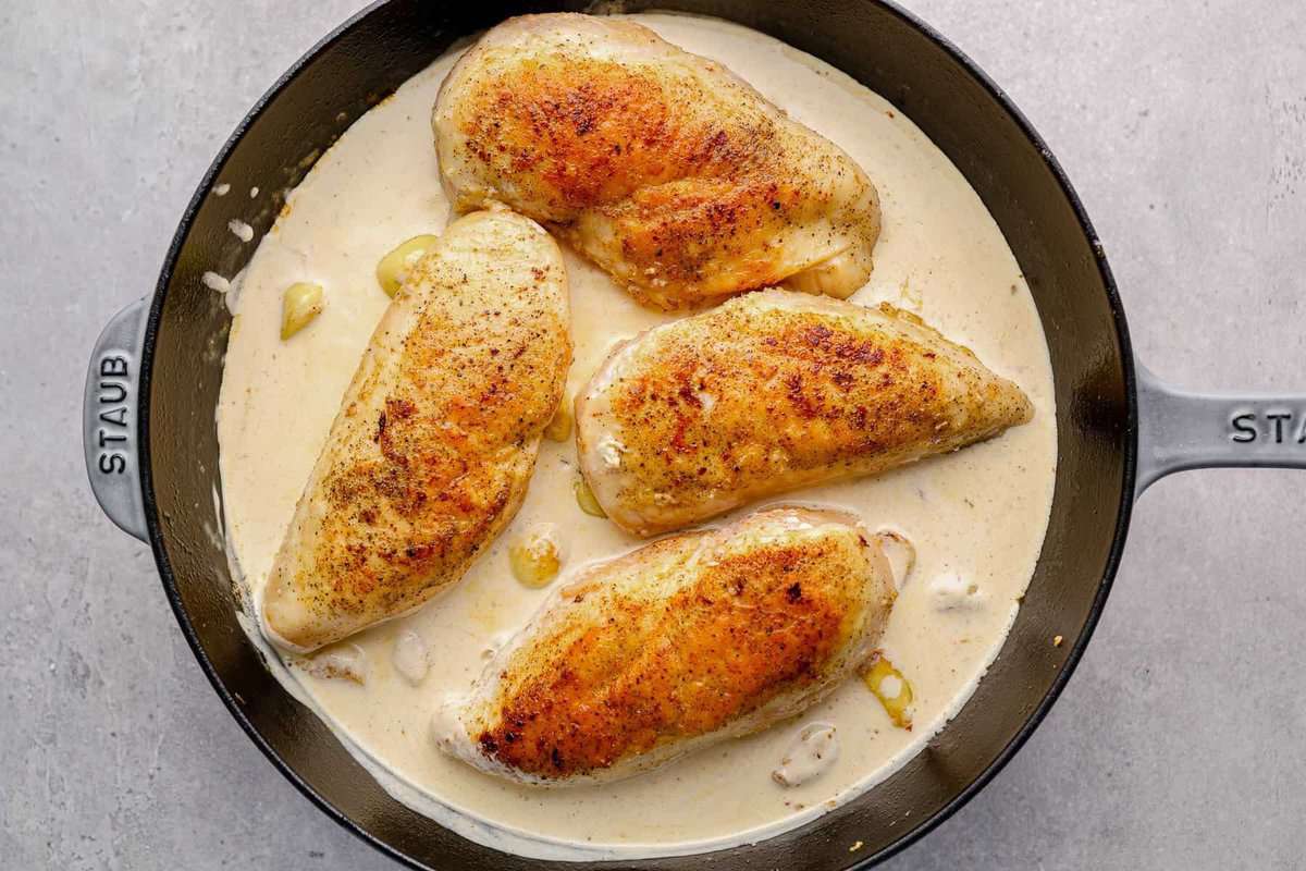 chicken breasts in creamy garlic sauce in a skillet