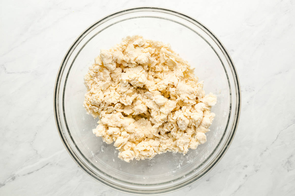 water, butter, and shortening cut into flour in a glass bowl.