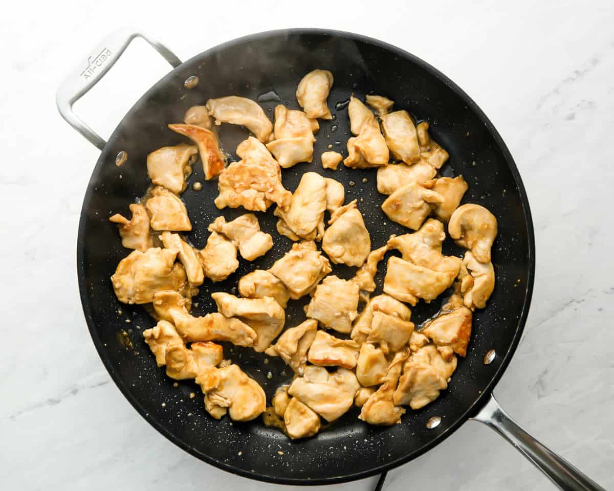 chicken cooking in black skillet