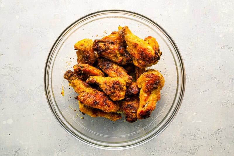 glass bowl filled with crispy chicken wings tossed in lemon pepper sauce