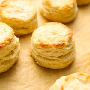 closeup three-quarters view of buttermilk biscuits on parchment paper.