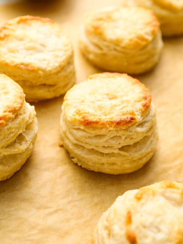 closeup three-quarters view of buttermilk biscuits on parchment paper.