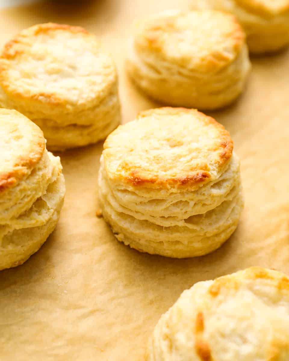 closeup three-quarters view of buttermilk biscuits on parchment paper.