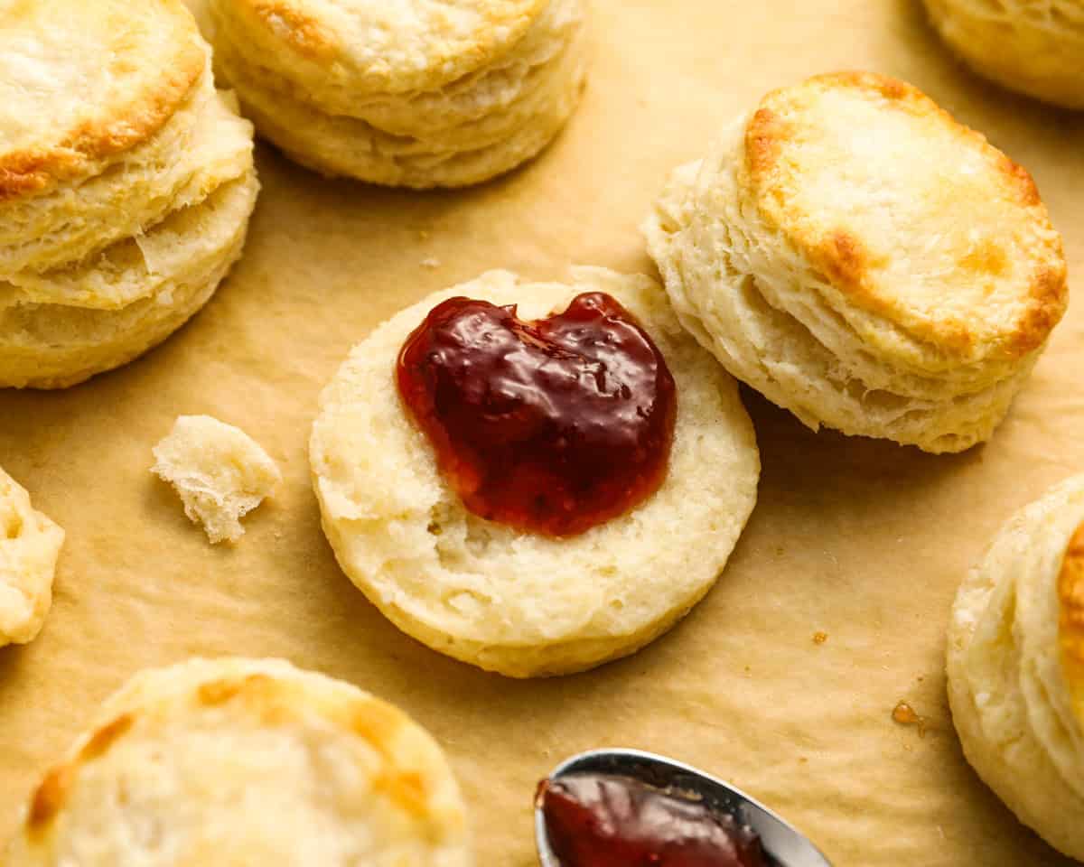 a halved buttermilk biscuit smeared with red jam.