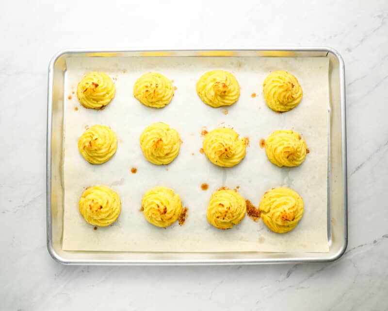 baked duchess potatoes on a baking sheet.