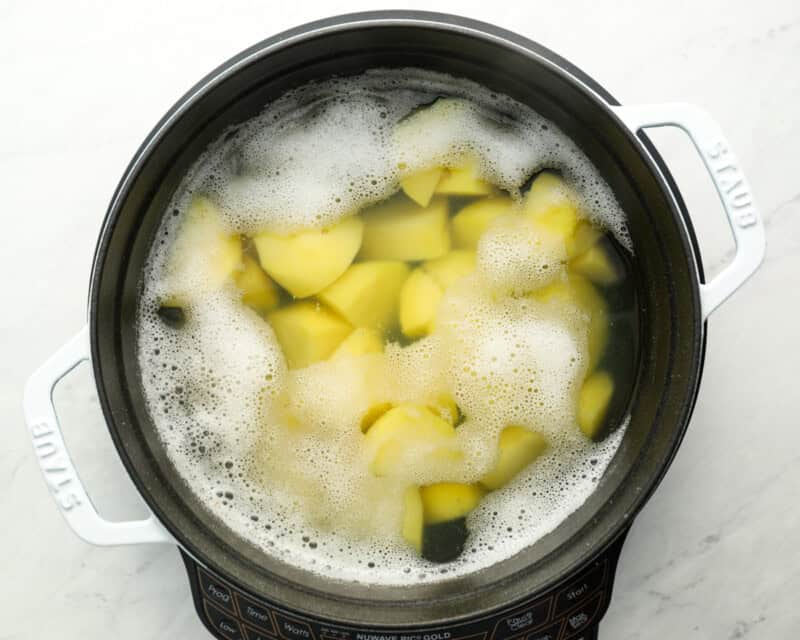 boiling quartered peeled potatoes in water.