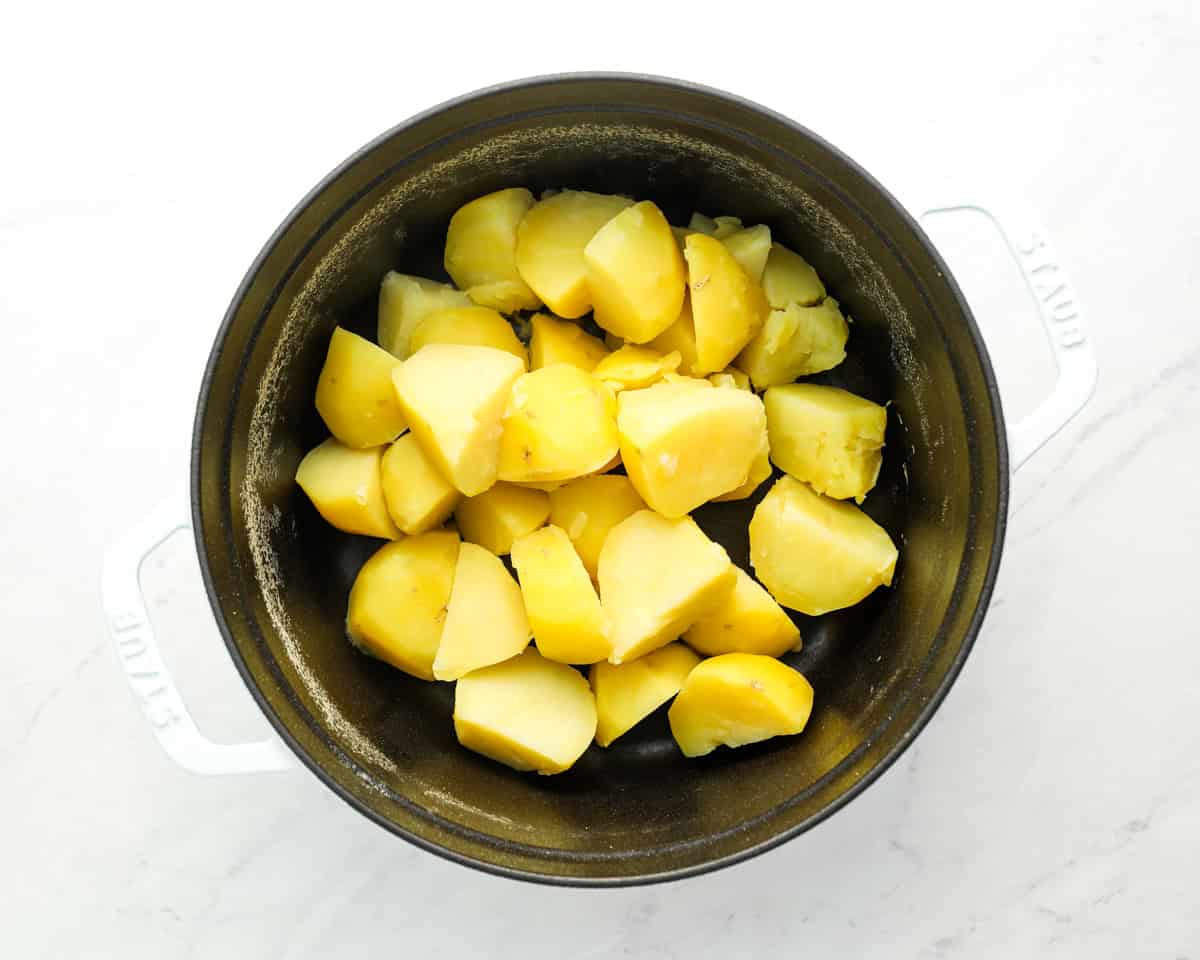 cooked quartered and peeled potatoes in a pot.