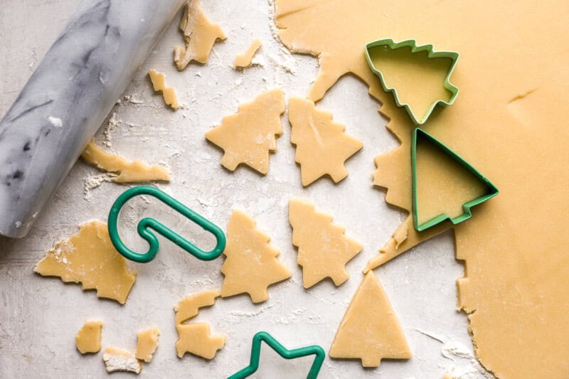 cutting out christmas shapes from cookie dough.