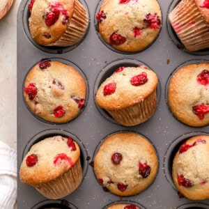 partial overhead view of cranberry muffins in a muffin tin.