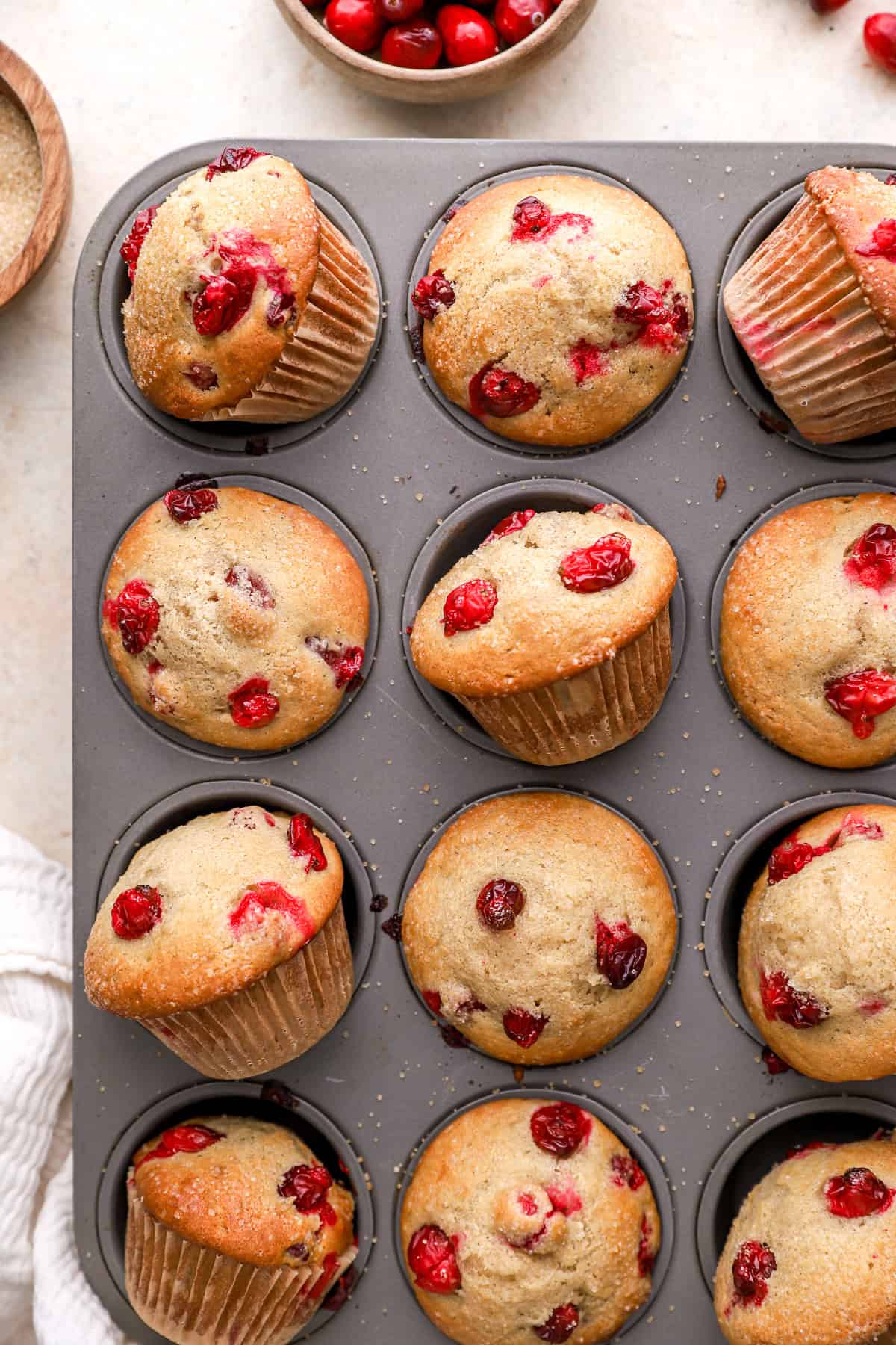 partial overhead view of cranberry muffins in a muffin tin.