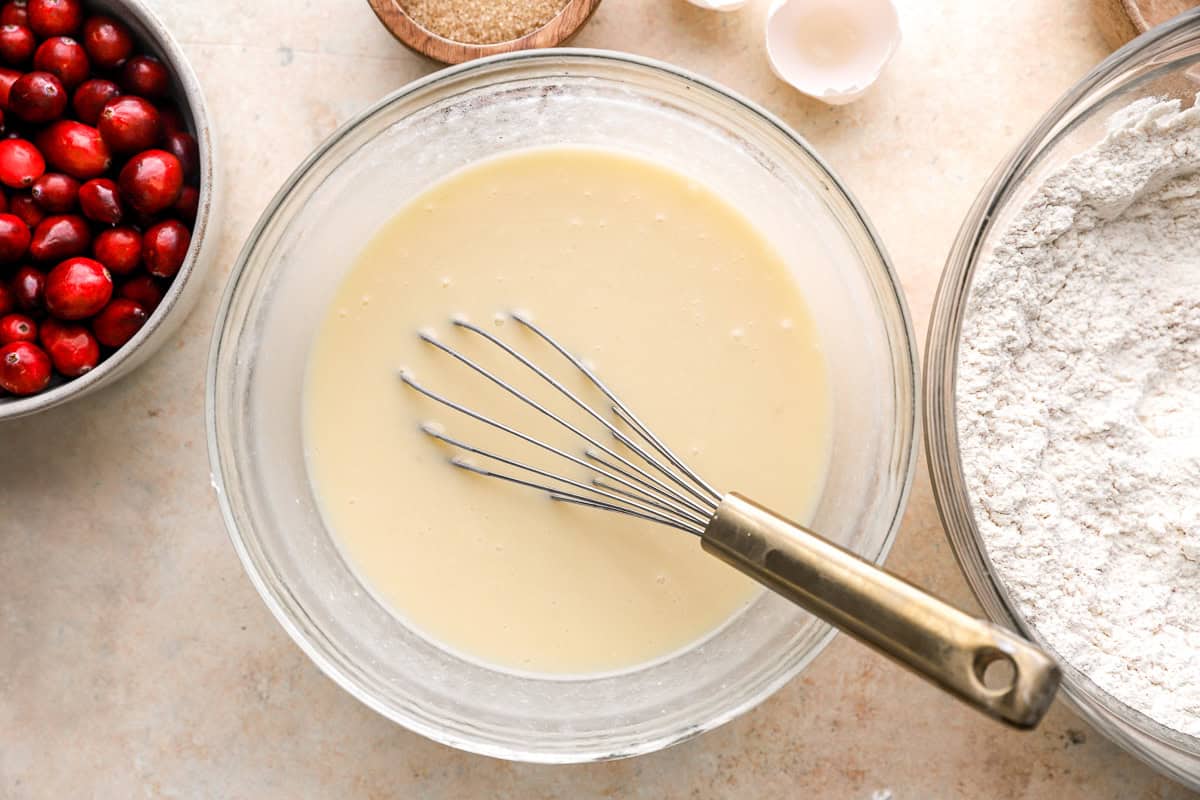 pale liquid in a glass bowl with a whisk.