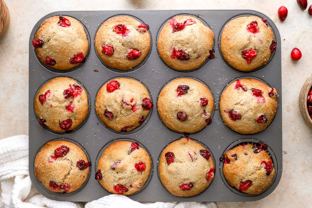 baked cranberry muffins in a muffin tin.