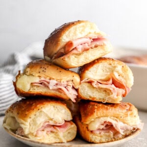 A plate of ham and cheese sliders on Hawaiian rolls.